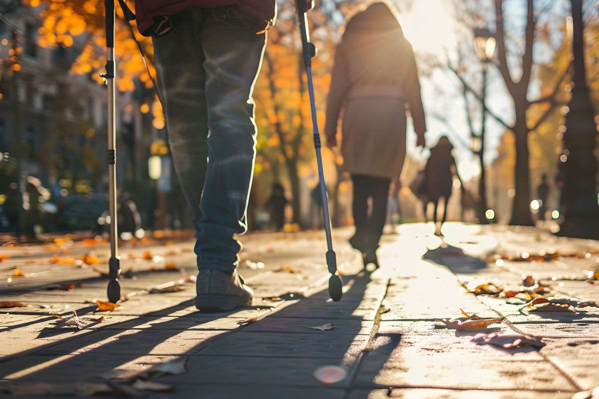 Man wallks through city park with crutches