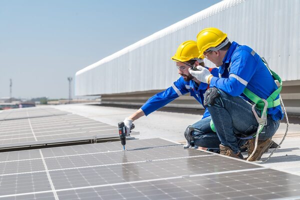 men fitting solar panels on retrofit building smart cities Adobe men fitting solar panels on retrofit building smart cities Adobe