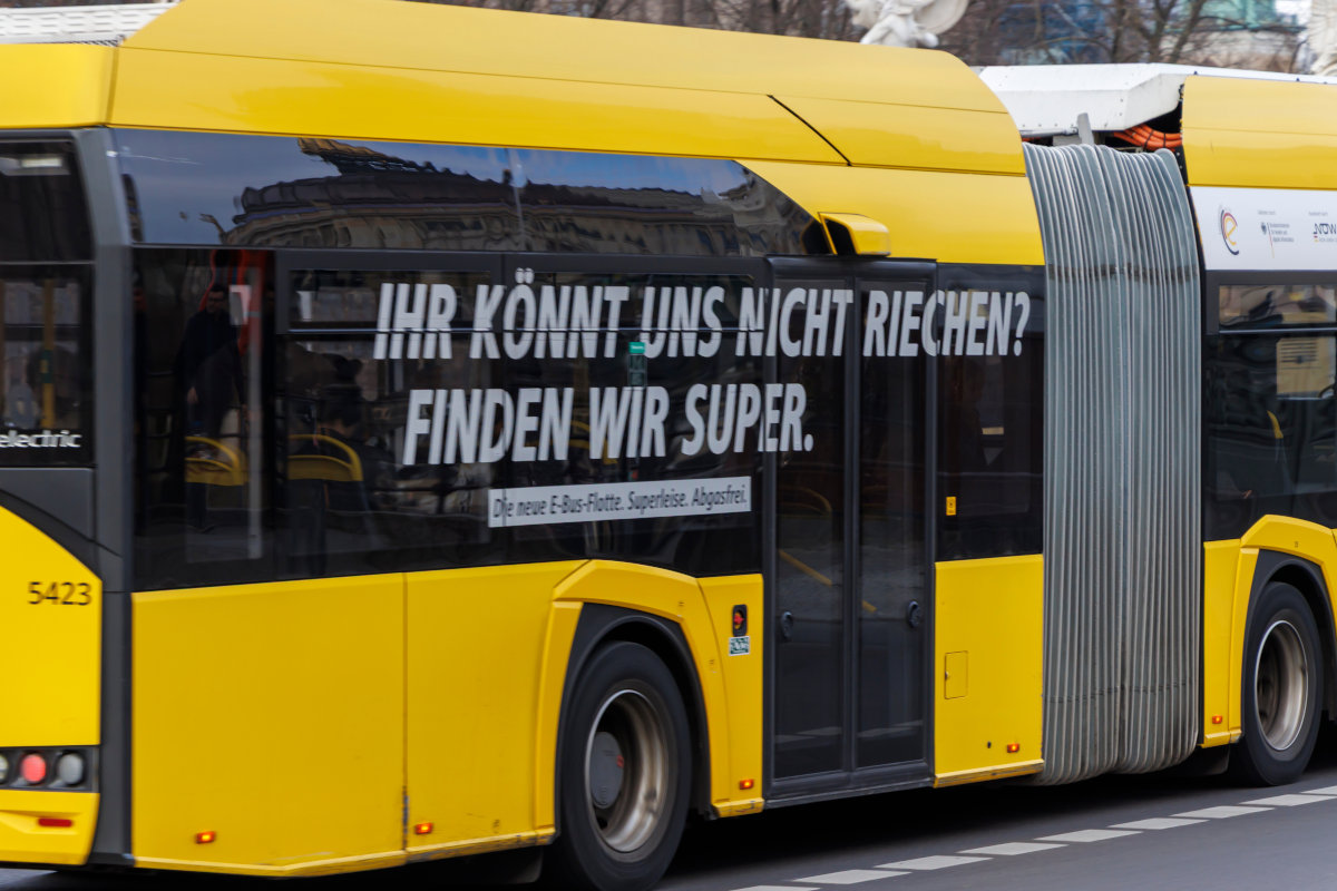 A yellow bus driving through the streets in Berlin, Germany